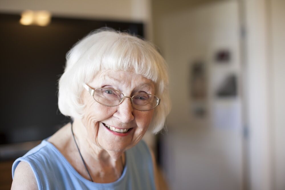 Senior woman smiling and enjoying memory care services at Bayshire Carlsbad