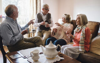 Group of seniors in assisted living talking and drinking coffee