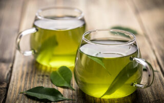 Close up of two cups of green tea on wooden table