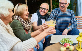 Senior group talking and eating outside having fun