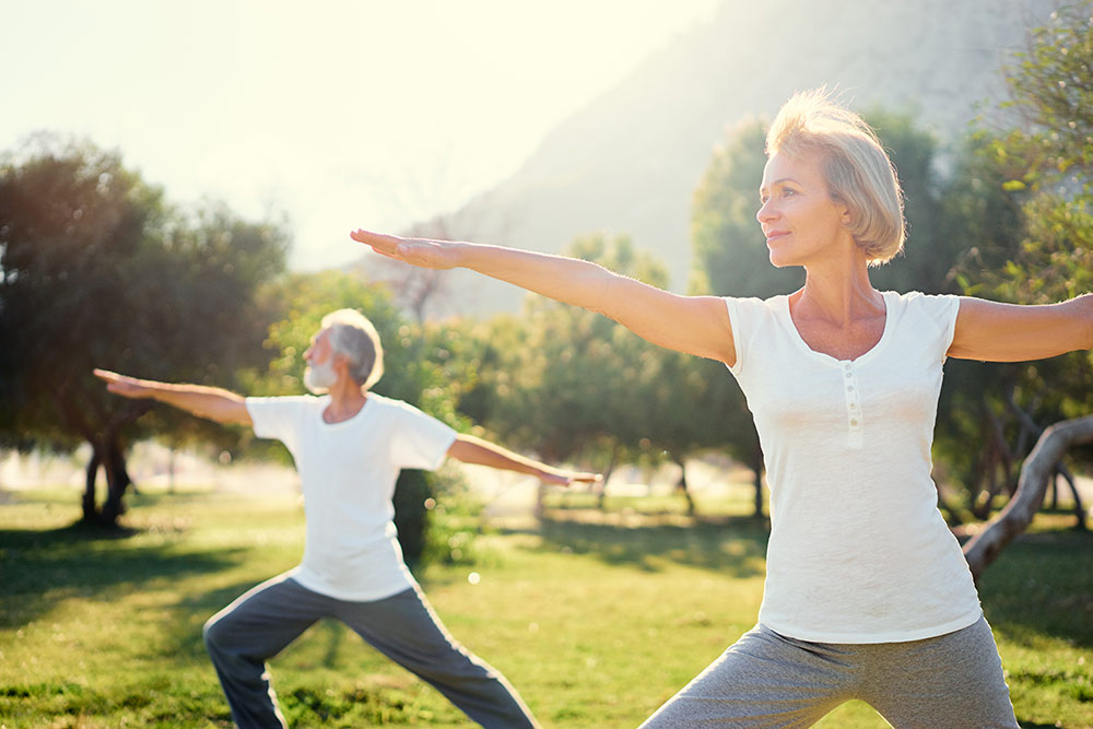 Seniors outside doing yoga