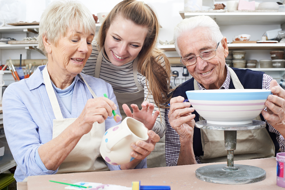 A senior couple takes a pottery class