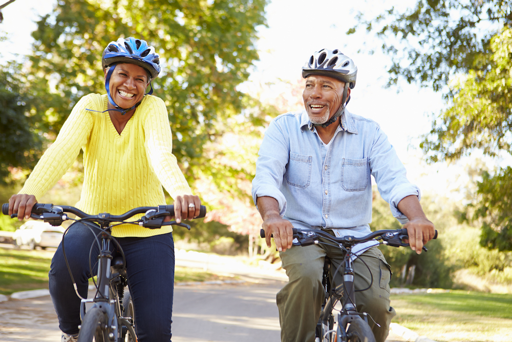 Two seniors enjoy a bike ride outdoors