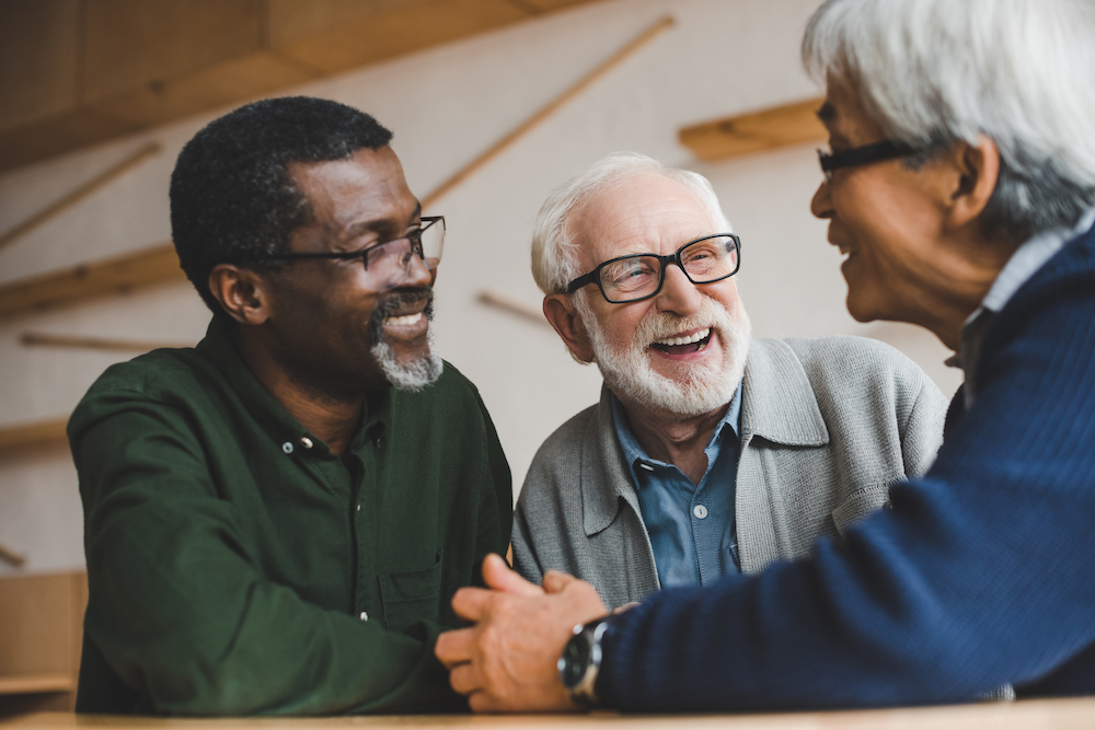 Three senior men laughing and chatting