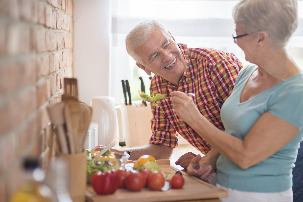 A senior couple preps a healthy meal together