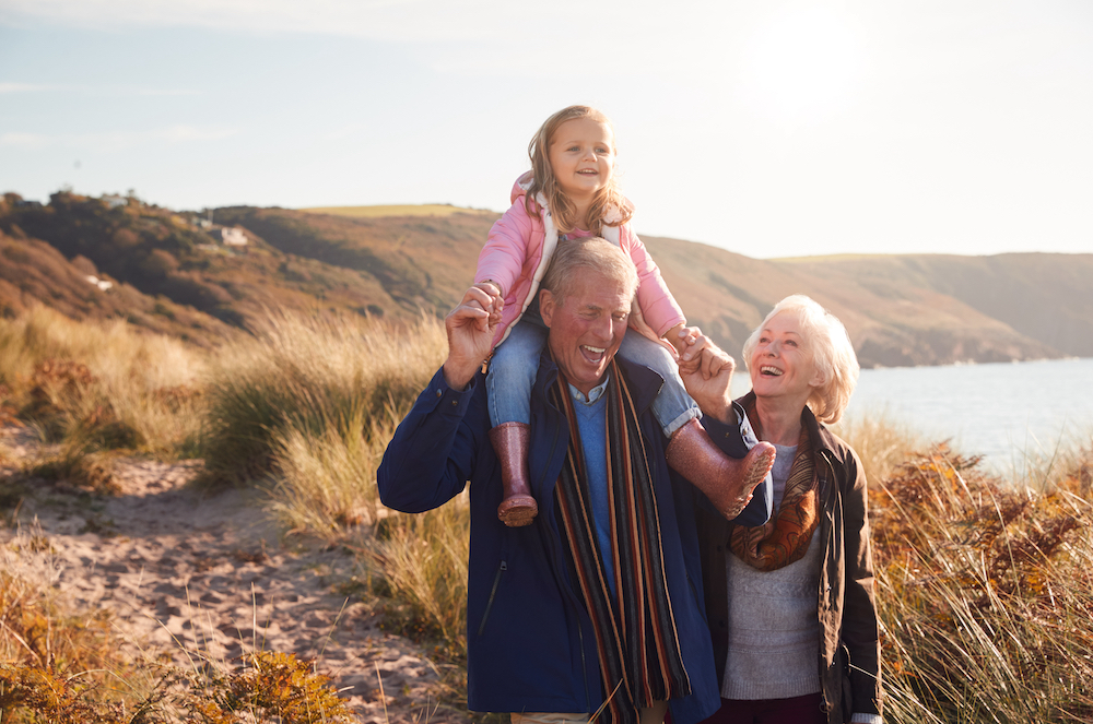 A senior couple go for a stroll with their granddaughter 