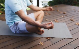 A senior man doing yoga outdoors