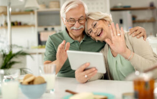 A happy senior couple uses their tablet to connect to others