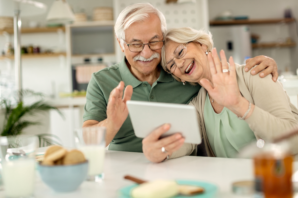 A happy senior couple uses their tablet to connect to others