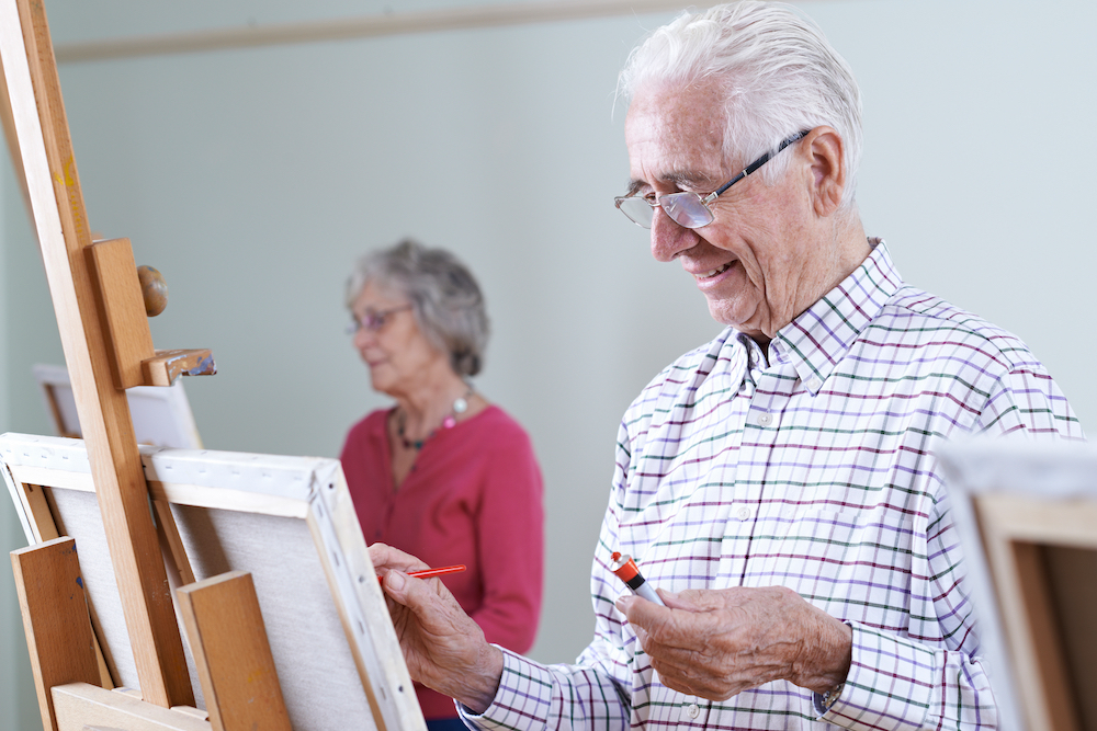 A group of seniors participate in a painting class