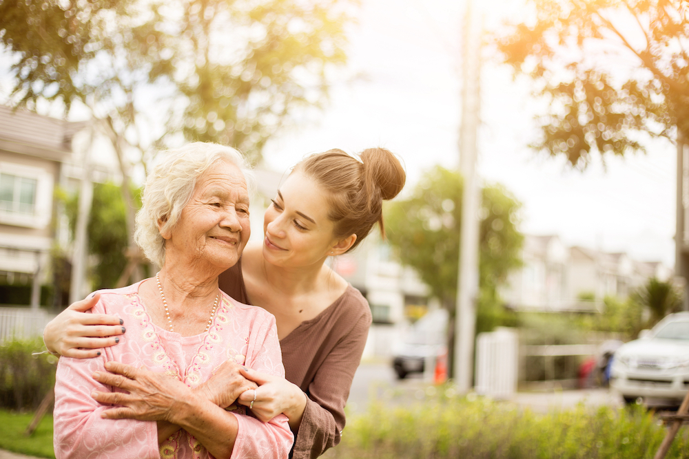 A young woman hugs her senior mother