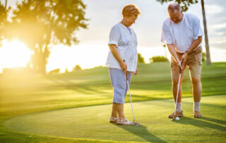 An active senior couple golf together