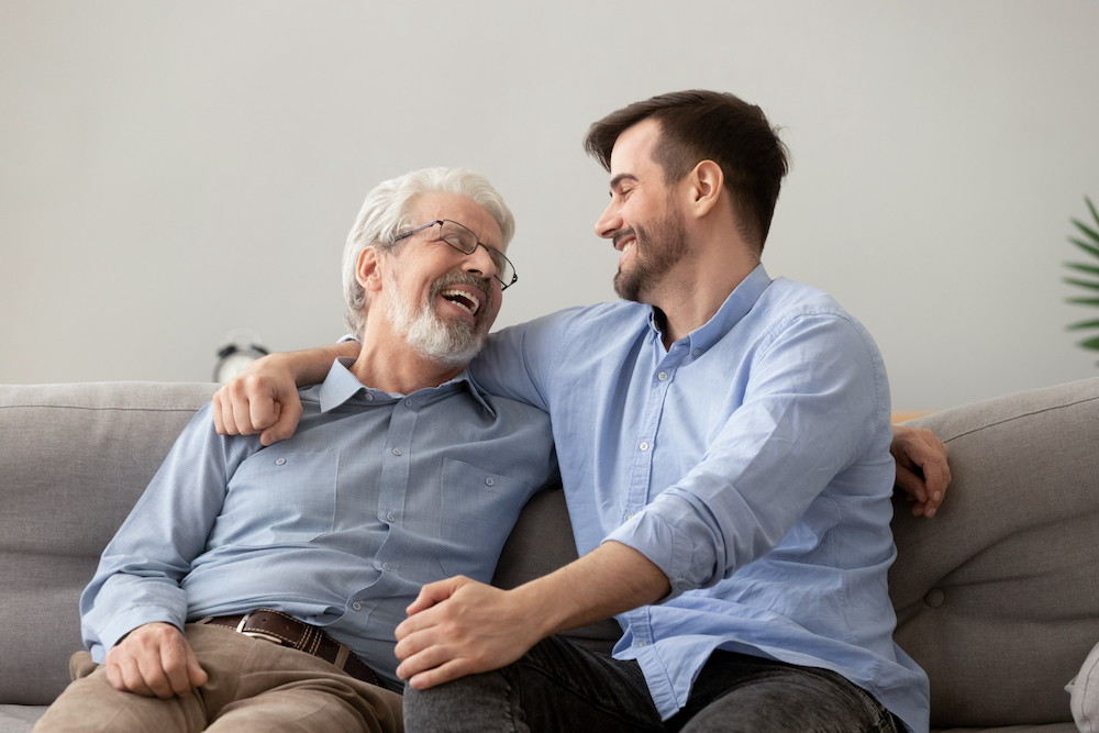 A senior man and his son sit and talk