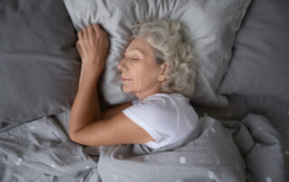 A senior woman sleeping soundly in bed at one of the Carlsbad retirement communities