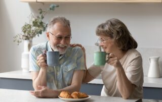 A happy senior couple enjoys breakfast and coffee at the senior living in Carlsbad