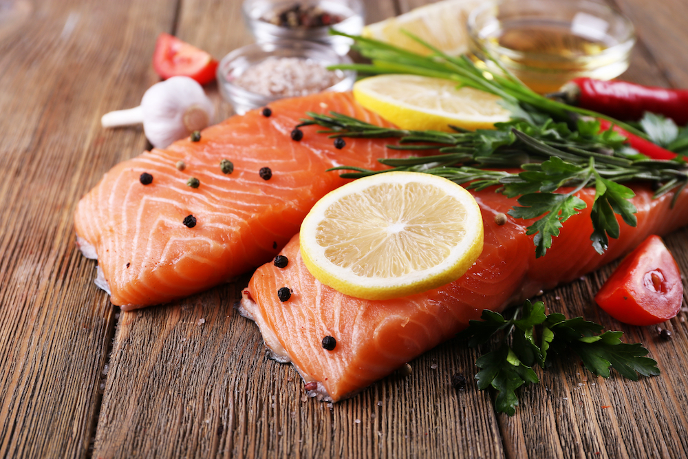 Cuts of fresh salmon with lemon slices and herbs