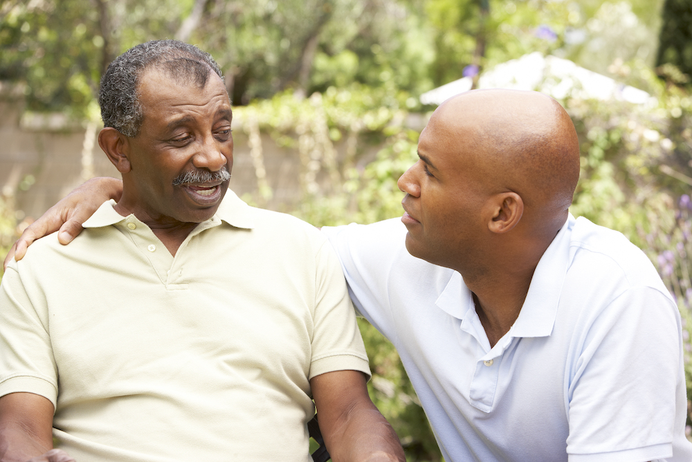An adult man having a conversation with his senior father about moving to the memory care in Carlsbad