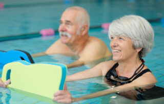 Residents of the senior living in Carlsbad, CA taking a water aerobics class together