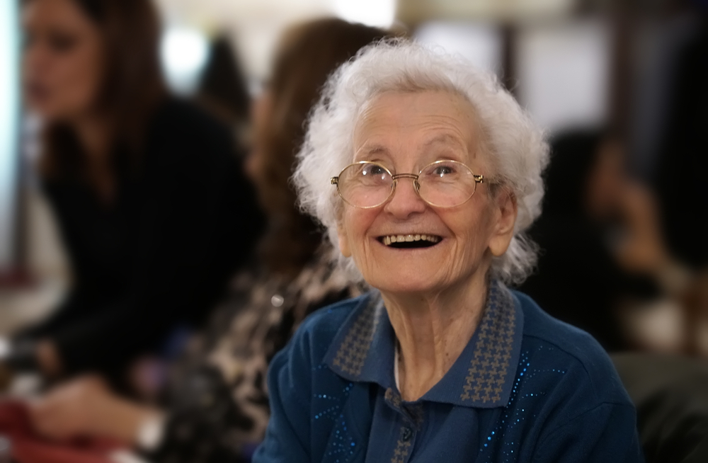 Elderly woman smiling while enjoying memory care services at Bayshire Carlsbad