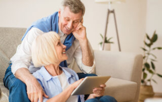 Senior couple looking at assisted living oceanside on their tablet