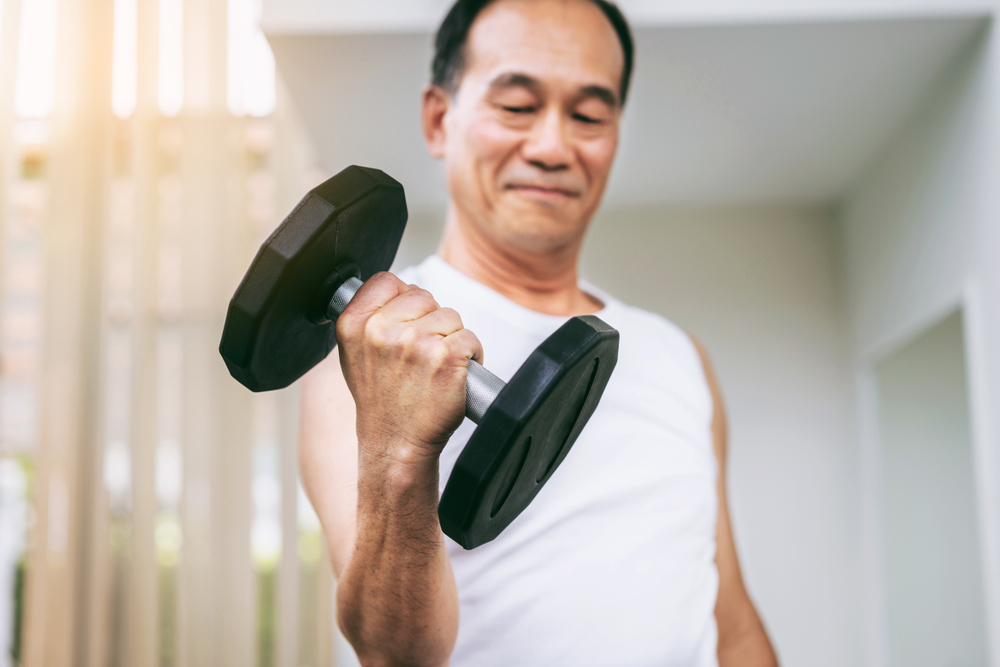 senior man lifting dumbbell to work on bone strength at senior living in carlsbad ca