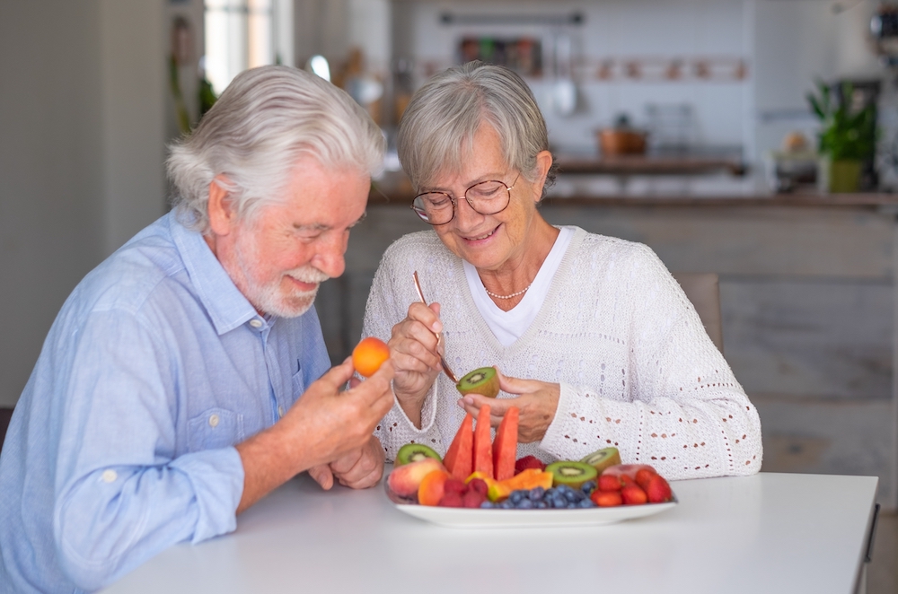 A happy senior couple eating a healthy breakfast