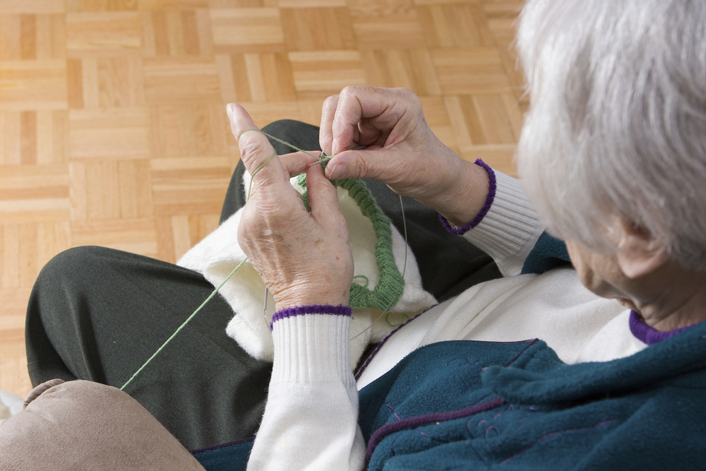 Senior knitting in independent living Oceanside, CA.