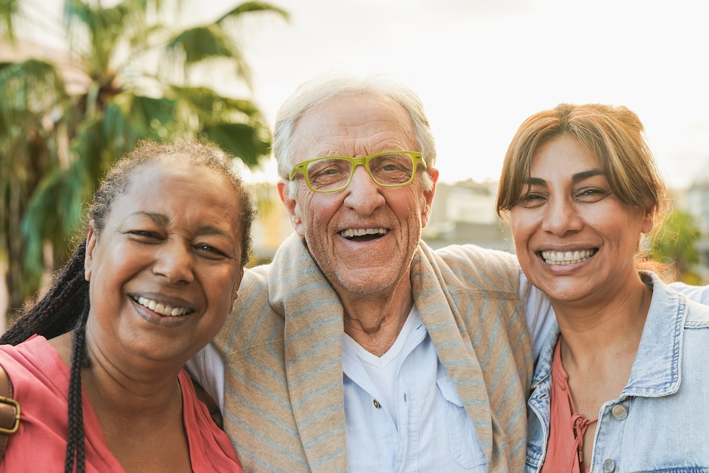 Senior man with two women outside enjoying Carlsbad Senior Living Communities