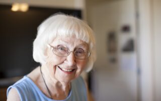 Senior woman smiling and enjoying memory care services at Bayshire Carlsbad